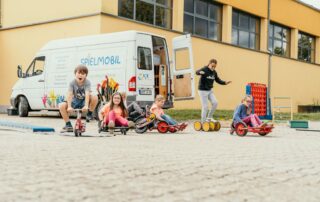 Spielende Kinder vor dem Spielmobil