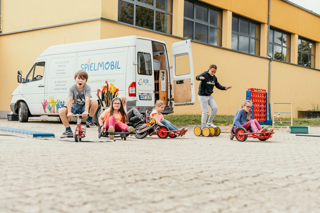 Spielende Kinder vor dem Spielmobil