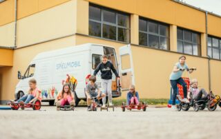 Spielende Kinder vor dem Spielmobil