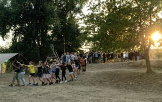 Die Teilnehmer des Inklusiven Zeltlagers laufen einer Flöte spielenden Person in einer Polonaise hinterher