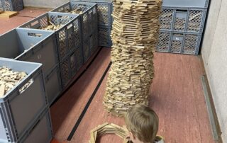 Ein kleines Kind baut einen Turm aus Holzklötzen