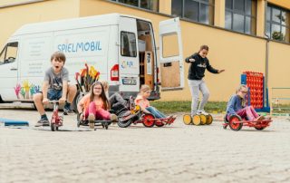 Spielende Kinder vor dem Spielmobil