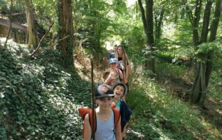 Kinder in einer Reihe beim Wandern durch den Wald