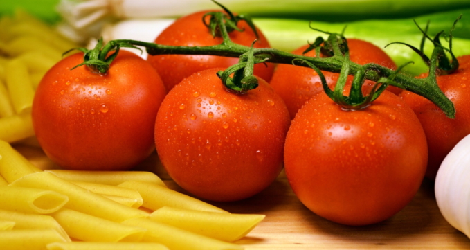 Tomaten auf einem Brett zwischen Nudeln