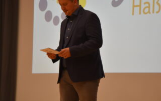 Der Moderator Peter Kraus steht auf der Bühne und moderiert