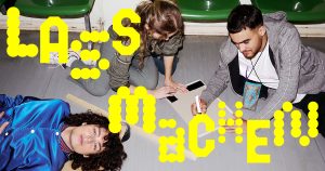 Schriftzug "Lass machen" vor drei Jugendlichen, die auf dem Boden ein Plakat bemalen