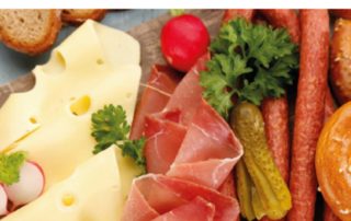 Schinken, Käse und Wurst mit Gurken und Radieschen auf einer Platte