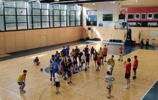 Jugendliche in einer Halle beim Basketballtraining
