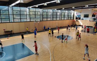Jugendliche in einer Halle beim Basketballtraining in einzelnen Übungen