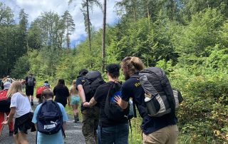 Die Gruppe des inklusiven Zeltlagers auf Wanderung schiebt sich gegenseitig an.