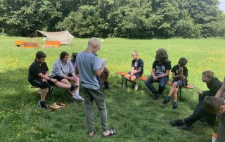 Eine Runde einiger Kinder spielen Werwolf beim Zeltlager