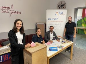 Die U18 Wahl in der Realschule Hofheim mit dem stellvertretenden Schulleiter Frank Ziegler, einer Schülerin, Vorstandsmitglied Caroline Petersen und Kreisjugendring Vorsitzendem Thomas Wagenhäuser. Die Schülerin wirft den Umschlag in die Urne