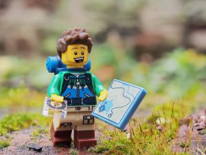 Eine Lego Figur, die wie ein Wanderer aussieht, steht im Wald