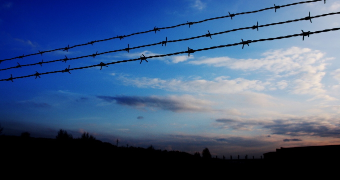 Himmel mit Farbverlauf und Stacheldraht im Vordergrund