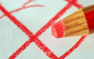 Roter Buntstift vor rotem Wahlkreuz