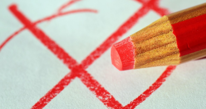 Roter Buntstift vor rotem Wahlkreuz