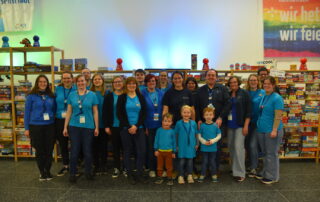 Helferinnen und Helfer in blauen T-Shirts