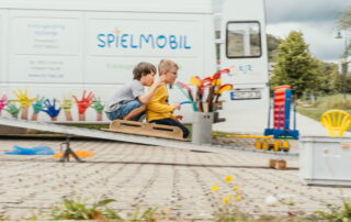 Zwei Jungs sitzen zusammen auf der Rollenrutsche