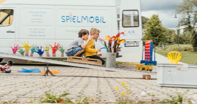 Zwei Jungs sitzen zusammen auf der Rollenrutsche