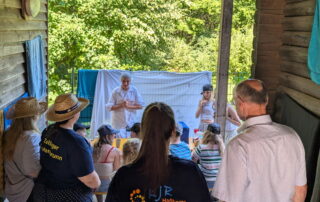 Landrat Wilhelm Schneider und Petra Erickson schauen der Mädelsgruppe an der "Milchtasting"-Station zu.