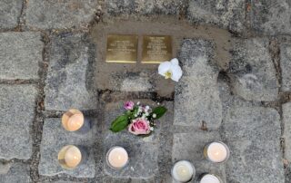 Zwei der neu verlegten Stolpersteine in Zeil am Main, mit Kerzen und Blumen.