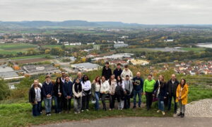 Ein Teil der israelischen Gruppe steht mit Gastfamilien am Aussichtspunkt vom Zeiler Käppele, im Hintergrund sieht man die Aussicht auf die Stadt Zeil und den Steigerwald.