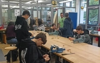 Im Werkraum der Mittelschule Haßfurt bearbeitem Jugendliche am Schraubstock Holz.