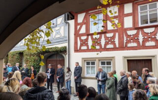Der isrealische Leiter Guy Hellenbrand liest bei der Stolpersteinverlegung in Zeil in der Mitte der großen Besuchergruppe das Kaddish.