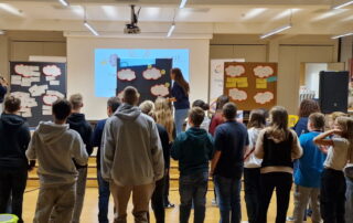 Die Teilnehmenden schauen bei der Zukunftswerkstatt Knetzgau auf die Pinnwände hören den Erklärungen von Anna-Maria Gebhardt und Eva Pfeil zur Auswertung der Konkretiserungsrunde zu.