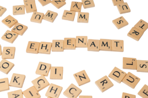 Viele Scrabble-Buchstaben auf denen in der Mitte "Ehrenamt" zu lesen ist.