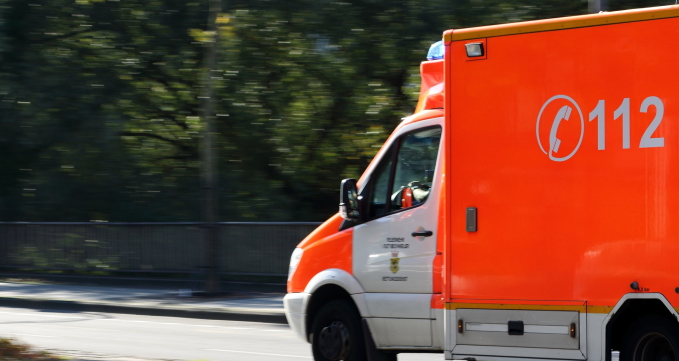 Ein Krankenwagen im Einsatz fährt auf einer Straße.